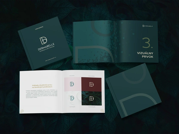 The DERMABELLE logo manual spread out on dark leaves
